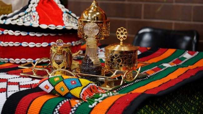 Decorative gold vessels displayed on colourful textiles