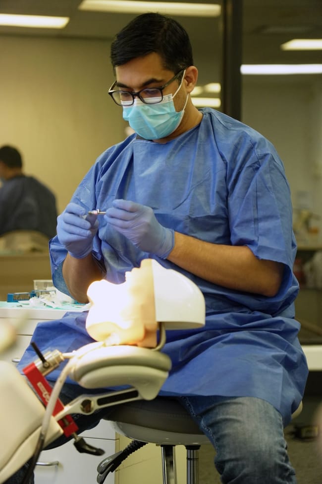 Dental trainee practising with a training model
