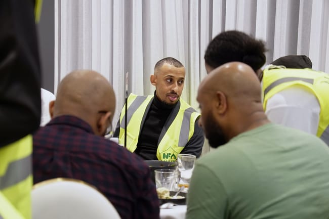 Volunteer speaking with guests at a table