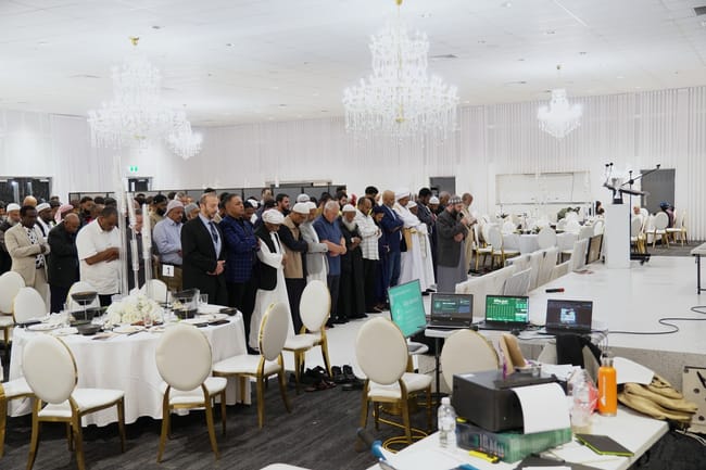 Wide view of group prayer in an event hall
